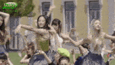 a group of people are dancing in front of a building with the words making jeans on the bottom