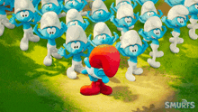 a group of smurfs are standing in a field and one of them is wearing a red hat