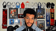 a man stands in front of a wall of hats and scarves including one that says united