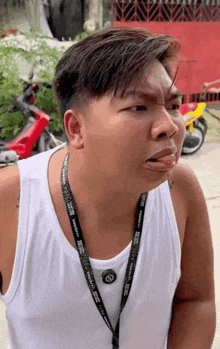 a man wearing a lanyard that says ' abercrombie & fitch ' on it is making a funny face