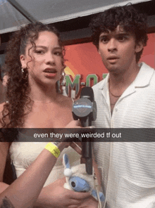 a man holding a microphone next to a woman with the words even they were weirded tf out below them