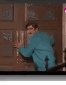 a man in a blue suit is standing in front of a refrigerator door .