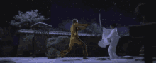 a man in a yellow suit is fighting a woman in a white suit