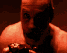a man without a shirt is holding a piece of bloody meat