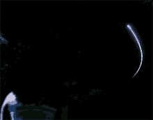 a shooting star is visible in the night sky above a person