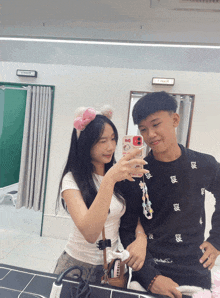 a boy and a girl are taking a selfie in front of a mirror with a sign on the wall that says " push "