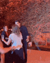 a group of people are dancing at a party with a man holding a microphone in his hand