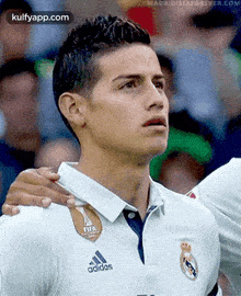 a close up of a soccer player wearing a white adidas shirt