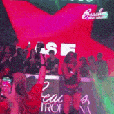 a woman is dancing in front of a sign that says beaches