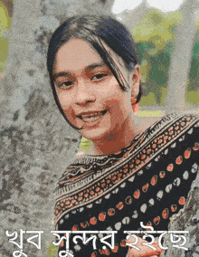 a girl in a polka dot dress is smiling in front of a tree and the words " shuv sundar ito " are below her