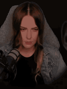 a woman is sitting in front of a microphone and making a face
