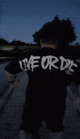 a man in a black shirt that says live or die