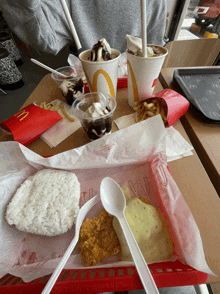 a person is sitting at a table with a mcdonald 's meal on it