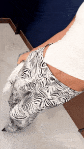 a woman wearing zebra print pants and a white crop top