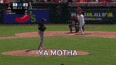 a baseball game is being played with a sign that says ya motha on it