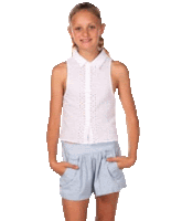 a young girl wearing a white shirt and blue shorts is standing with her hands in her pockets .