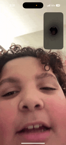 a person 's face is displayed on a phone screen with the time 2:31
