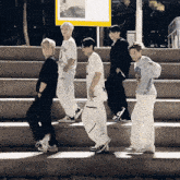 a group of people are walking down stairs with a yellow sign in the background