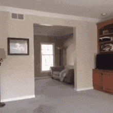 a living room with a picture on the wall and a lamp on the floor