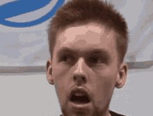 a close up of a man 's face with his mouth open and a blue circle in the background