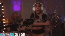 a woman wearing headphones is dancing in front of a microphone with a sub goal of 37.50