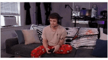 a man wearing headphones sits on a couch with a skull blanket