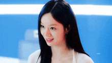 a woman with long black hair is smiling and wearing a white sweater .