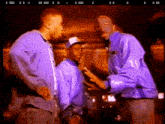 a group of men in purple jackets are standing next to each other