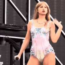 taylor swift is wearing a diaper while holding a microphone on stage .