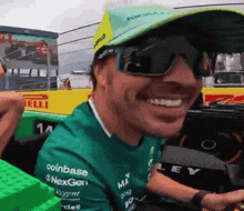 a man wearing sunglasses and a green shirt that says coinbase