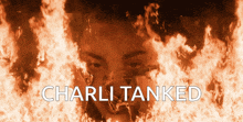 a poster for charli tanked shows a man in a gas mask surrounded by flames