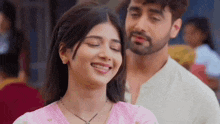 a man and a woman are smiling and looking at each other .