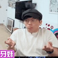 a man wearing glasses and a hat is making a funny face in front of a tv
