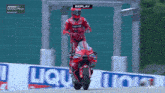 a man is riding a motorcycle on a track with a replay displayed on the screen .