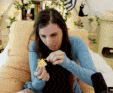 a woman sitting in a chair holding a lighter with the word toi on the screen