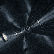 a dark room with a few lights on the walls and elevator going up