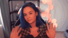 a girl with blue hair is sitting in front of a microphone