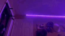 a person is dancing in a dark room with purple lights .