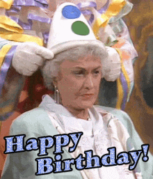 an elderly woman wearing a clown costume and a hat says happy birthday