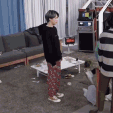 a man standing in a living room next to a table