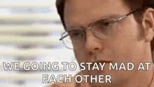 a man wearing glasses is talking to another man .