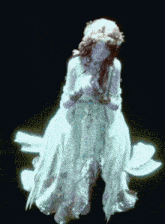 a woman in a white dress with a flower crown around her head