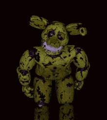 a yellow and purple stuffed animal with a sad face