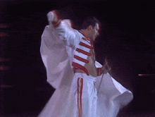 a man in a white shirt with red stripes on the sleeves