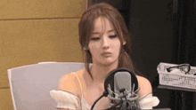 a woman is sitting in front of a microphone and making a funny face .