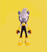 a cartoon character from the video game sonic the hedgehog is standing on a yellow background holding a block .