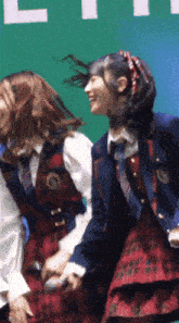 a girl in a plaid skirt is holding a microphone in her hand