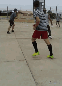 a group of young men are playing a game of soccer on a concrete court