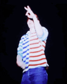 a man wearing a red white and blue striped shirt looks up