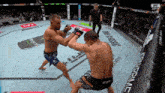 two men are fighting in a boxing ring with ufc written on the corner